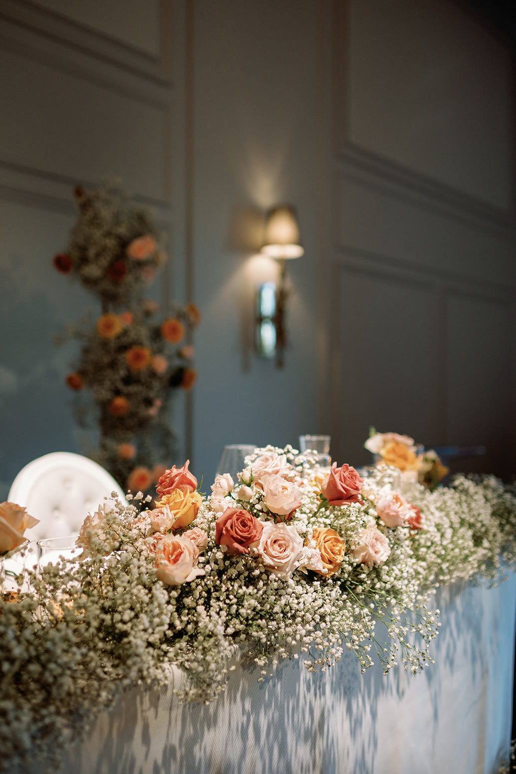 Head table garland of baby’s breath with peach and coral roses