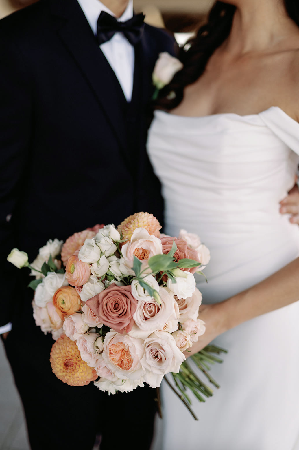 Kirsten’s bouquet of blush roses, peach ranunculus and orange dahlias
