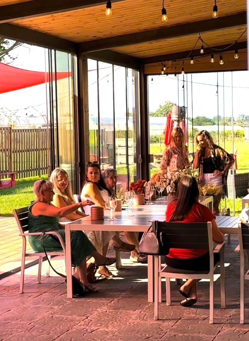 Guests gathered around a table on the patio at a summer workshop