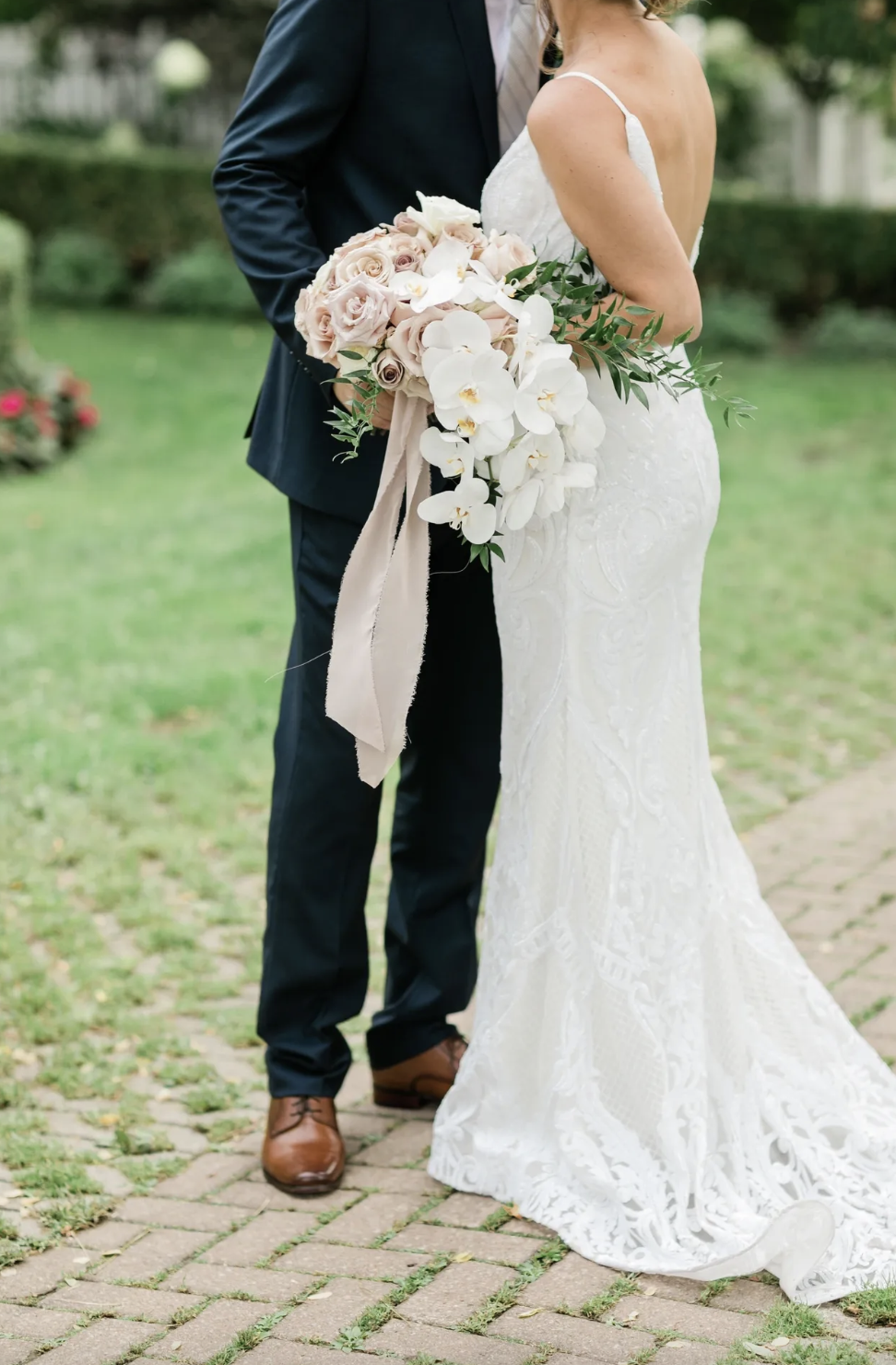 Kat and Alex together with her orchid and blush rose bouquet trailing silk ribbon