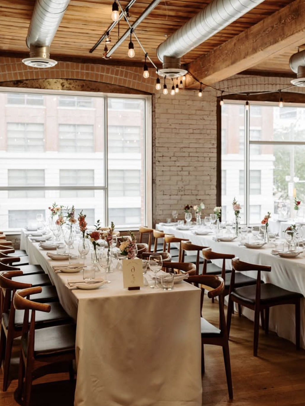 Hotel Ocho reception tables with bud vase wedding flowers