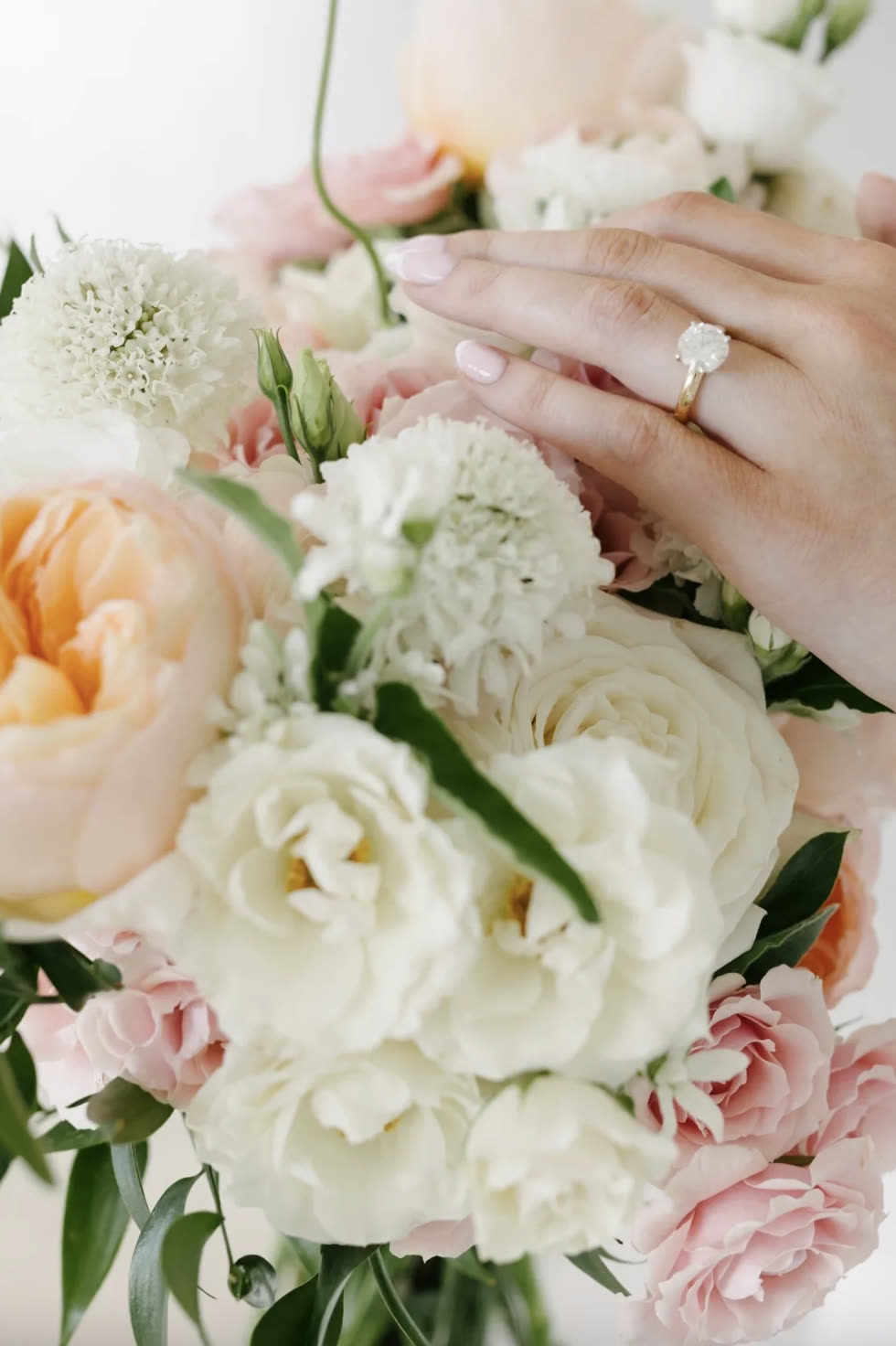 Bridget’s wedding ring resting on her blush and ivory bouquet