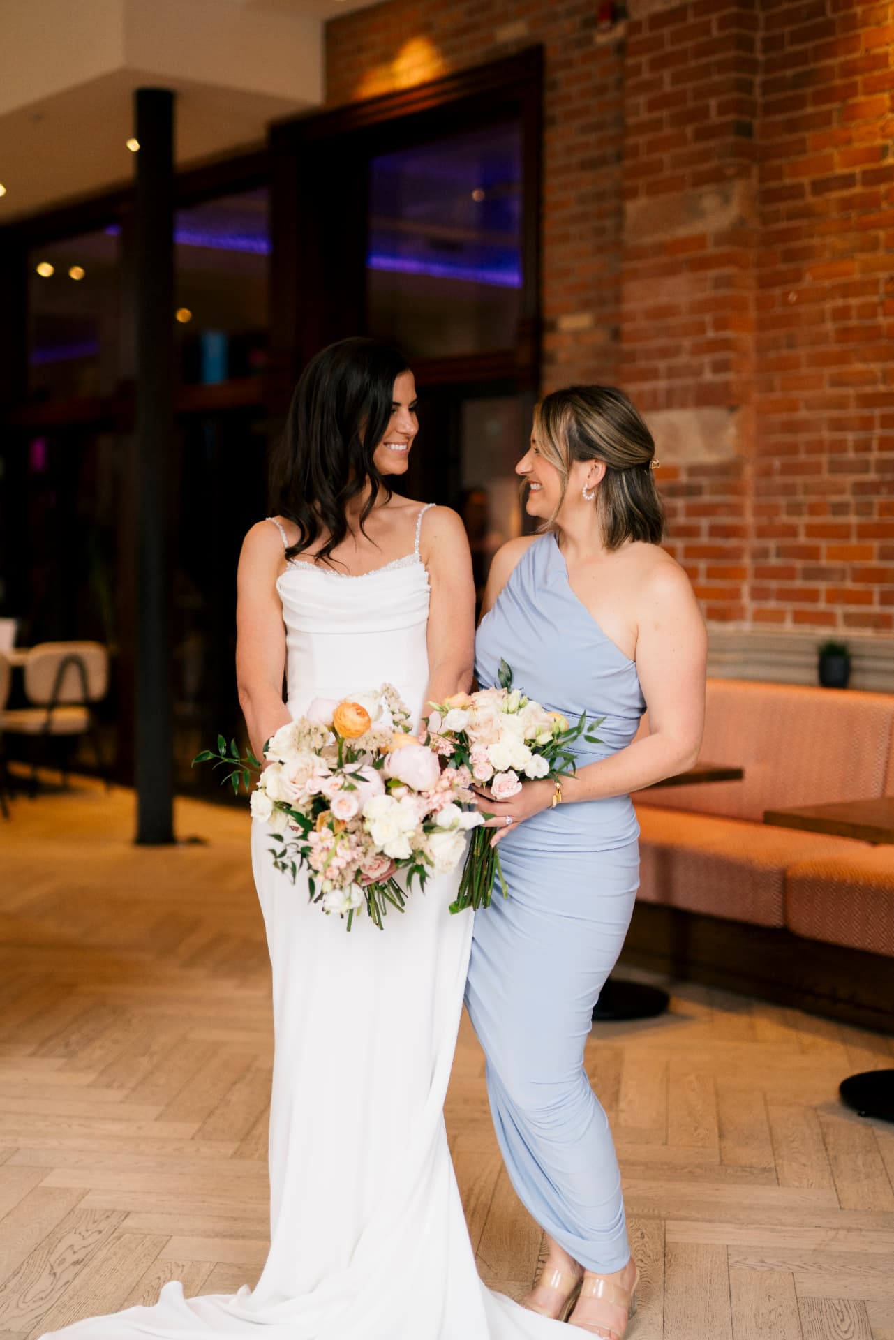 Hannah and her bridesmaid holding blush and ivory wedding bouquets