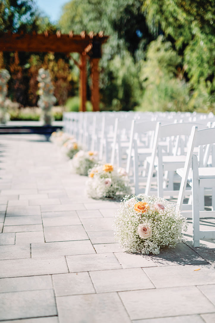 Baby’s breath and rose aisle arrangements lining the ceremony at Arlington Estate