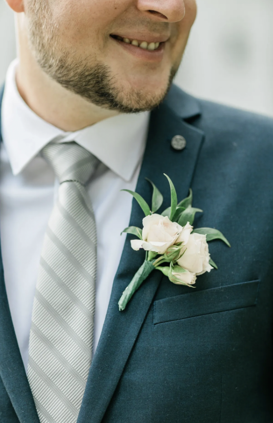 Alex’s blush spray rose boutonnière with ruscus on a navy suit