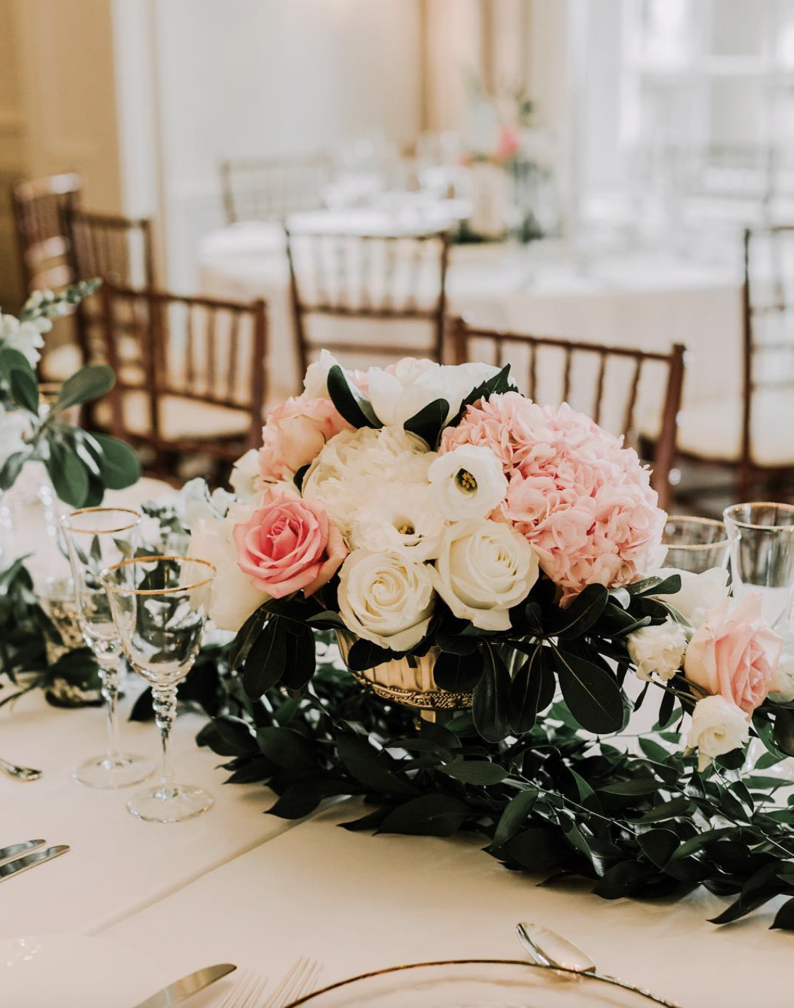 Blush hydrangea, pink and ivory rose centrepiece in a gold bowl on a greenery runner at Graydon Hall Manor
