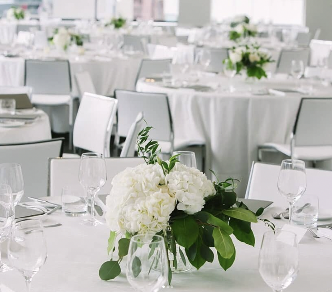 White hydrangea and greenery centrepiece on a reception table at Malaparte